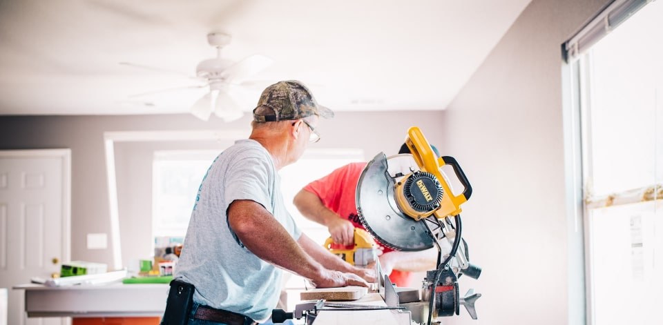 Two workers finishing an interior space